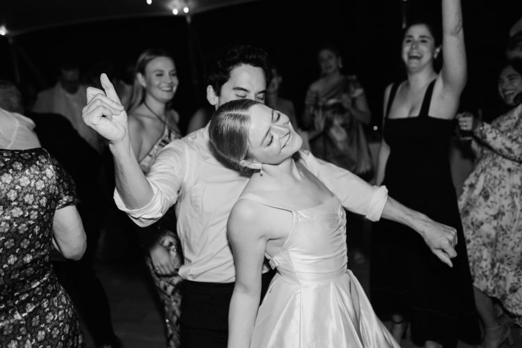 Couple dancing together on crowded wedding reception dance floor