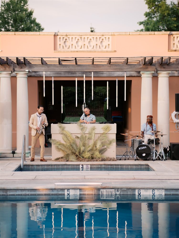DJ, saxophonist, and drummer performing poolside at outdoor wedding reception
